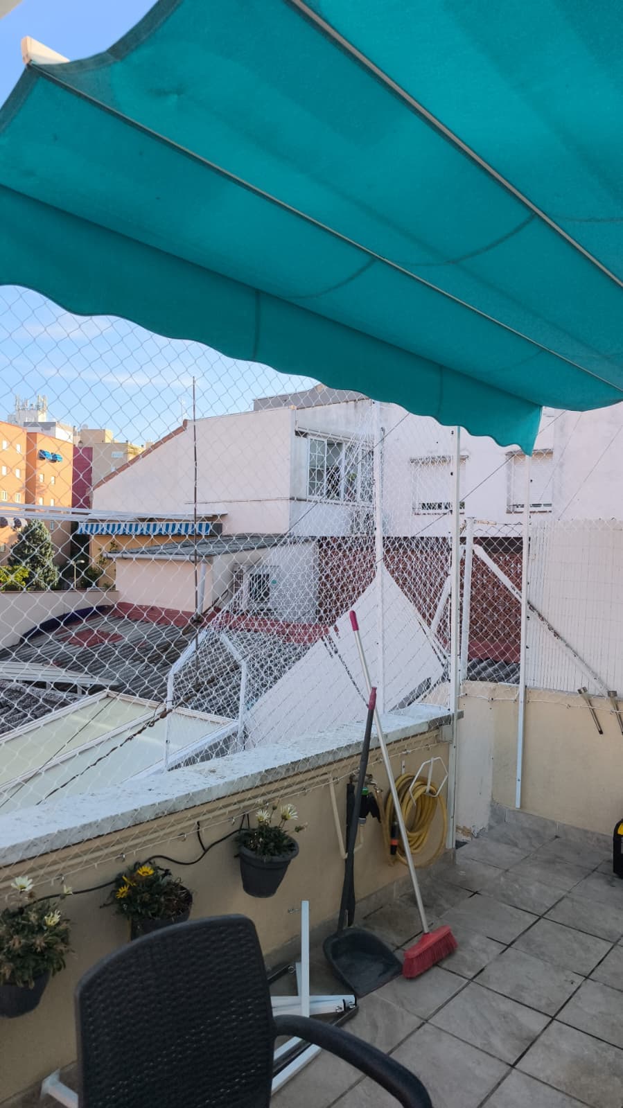 Terraza con toldo y malla de protección instalada en el perímetro