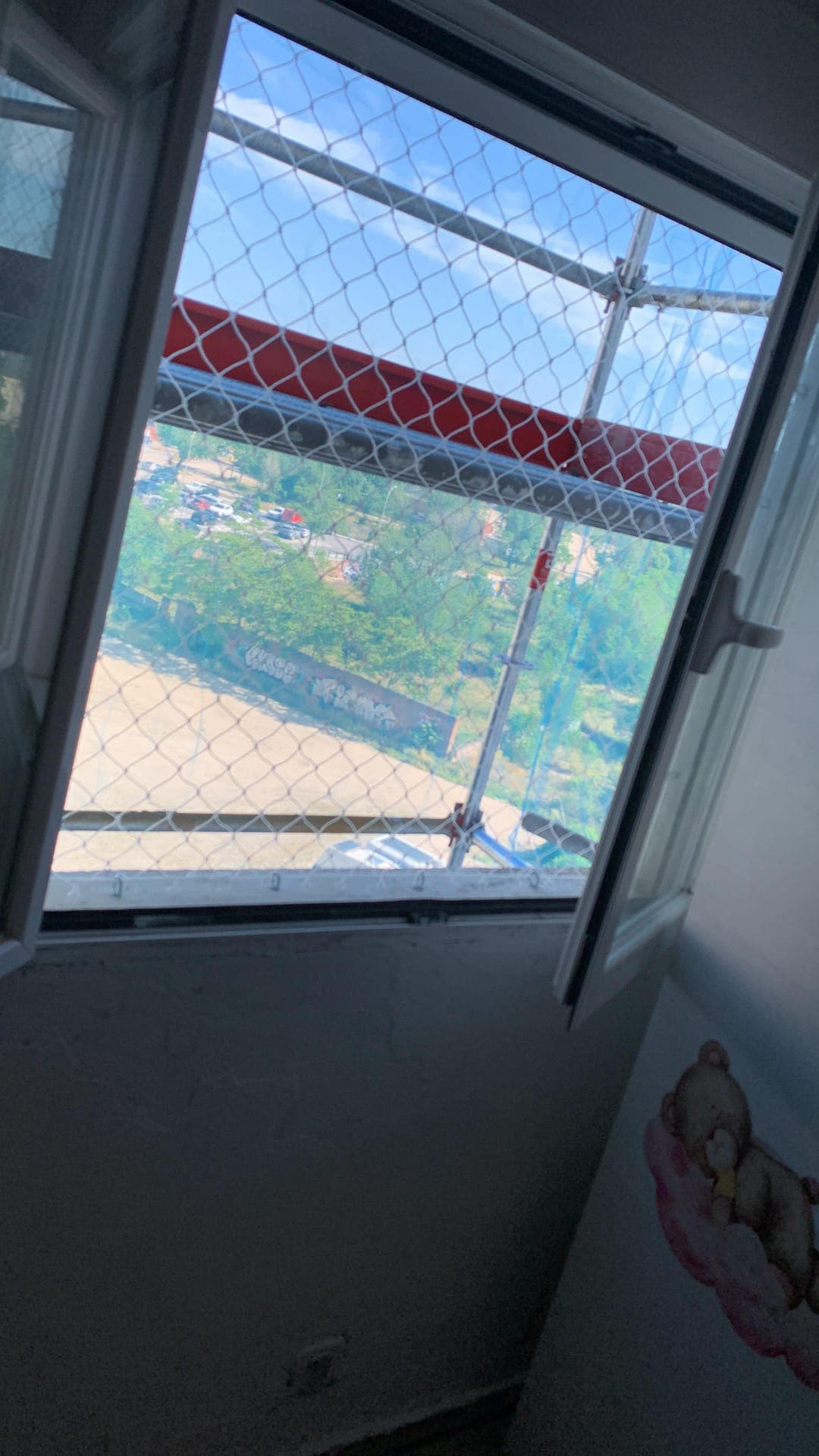 Ventana de una habitación infantil con red de protección instalada, con la hoja abierta